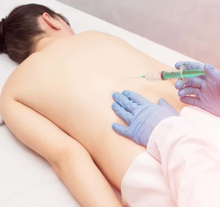 doctor injecting woman's back pain