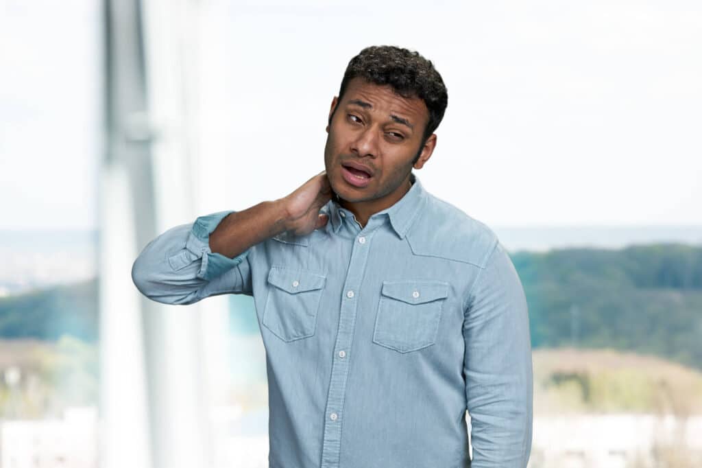 Unhealthy indian man suffering from neck pain.