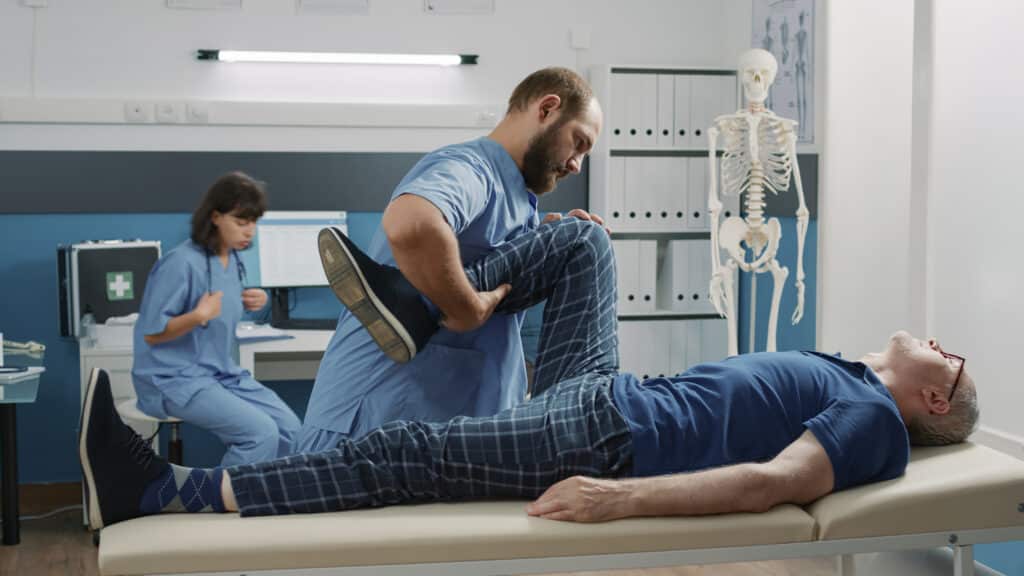 Patient working with physical therapist during evaluation for when to see a specialist for back pain